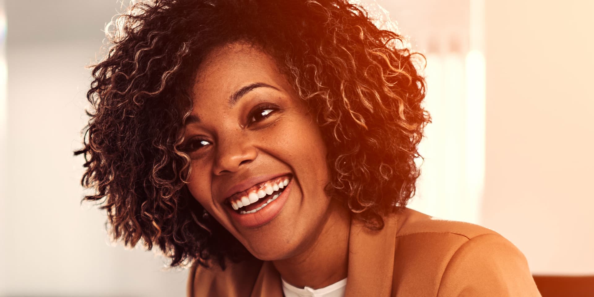 Woman smiling wearing a blazer.