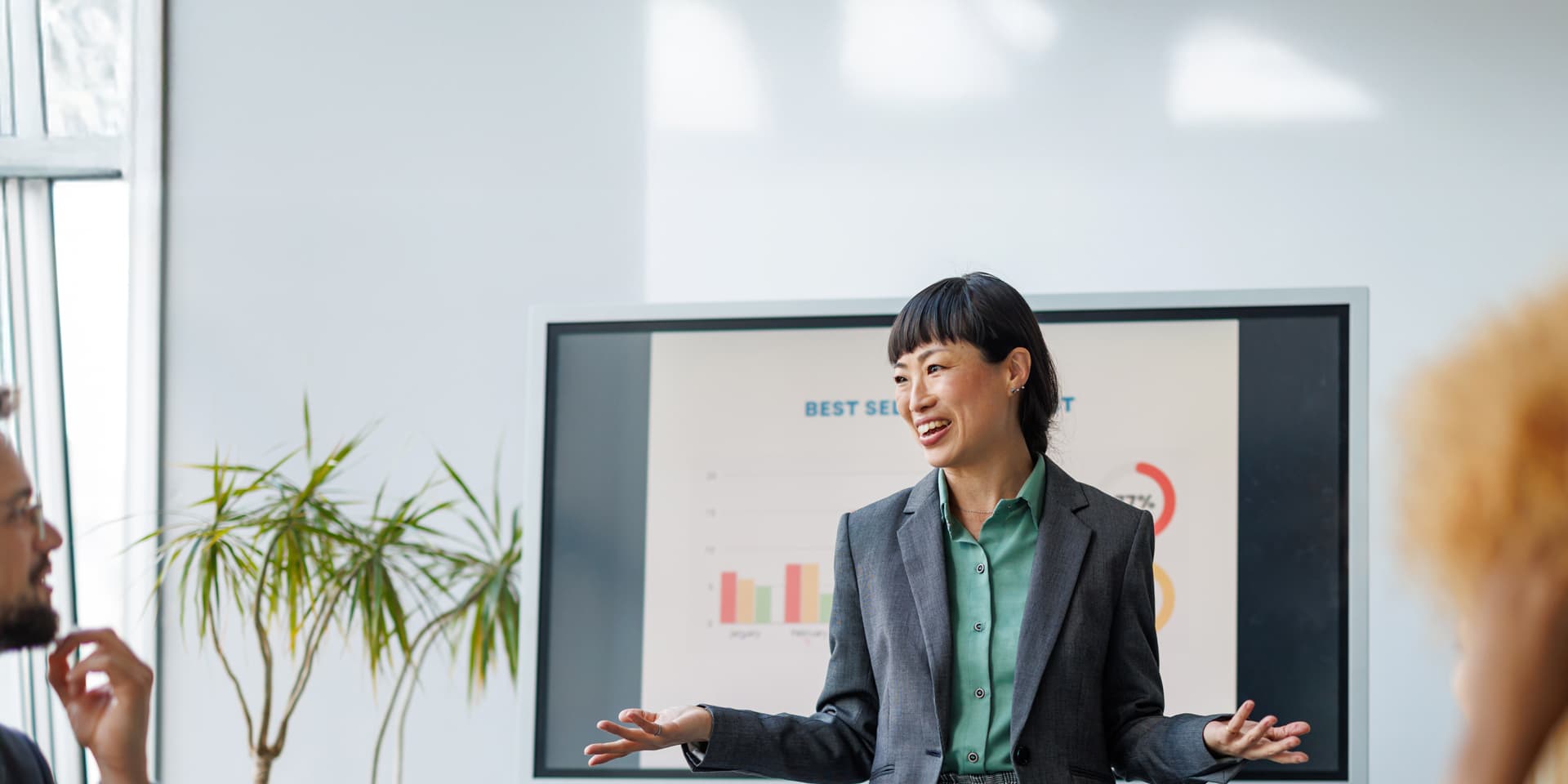 Professional woman in blazer gives MSc Business and Management presentation at meeting.