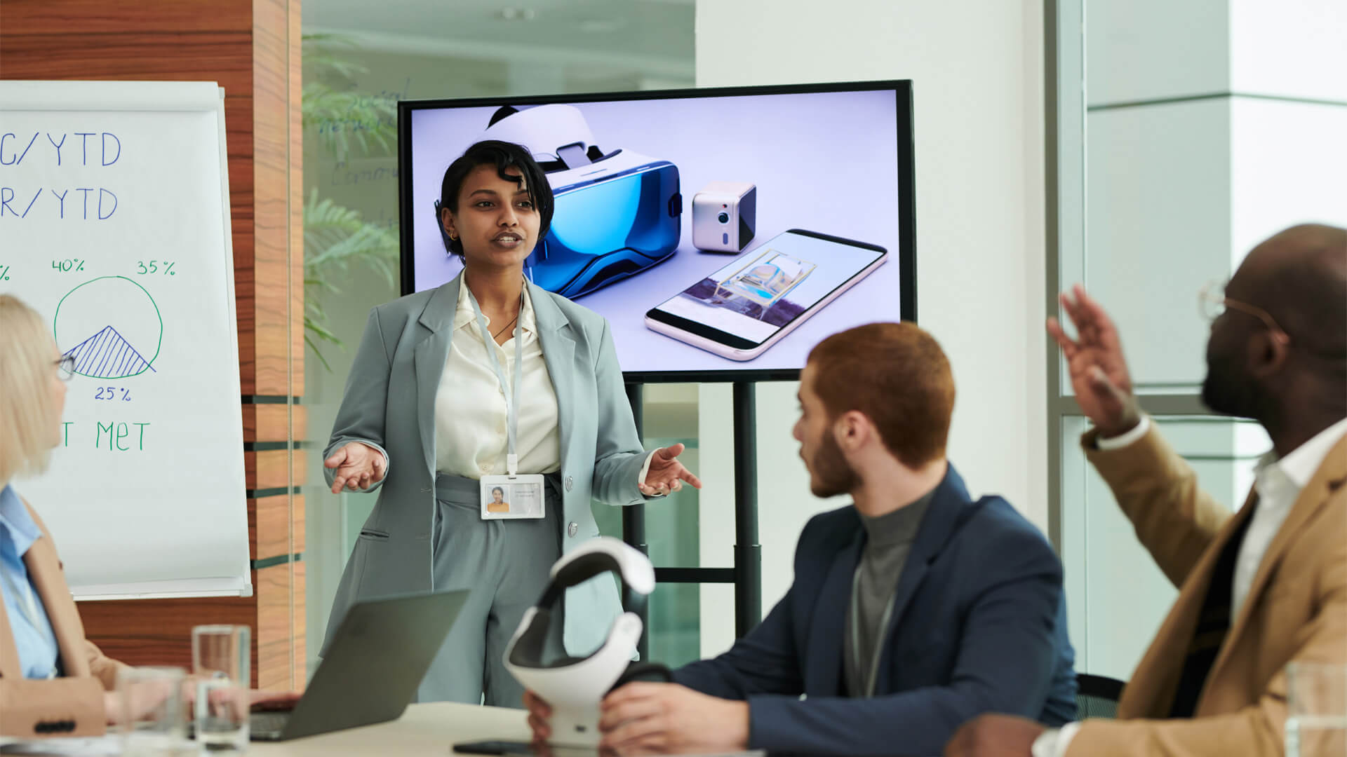 Online MBA graduate demonstrates leadership by presenting AI innovations to her team in a workplace session.