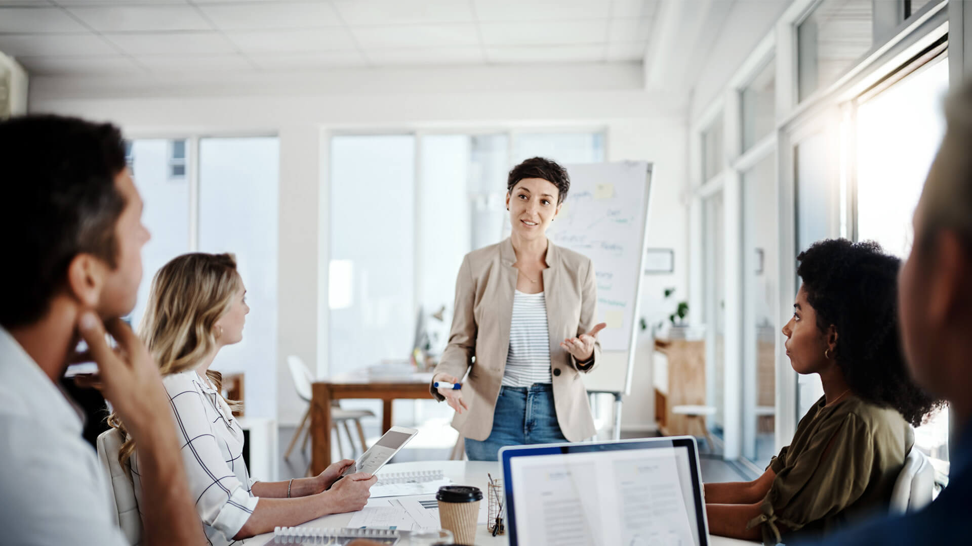 MBA Innovation graduate leads a strategy meeting, encouraging fresh ideas and team engagement.