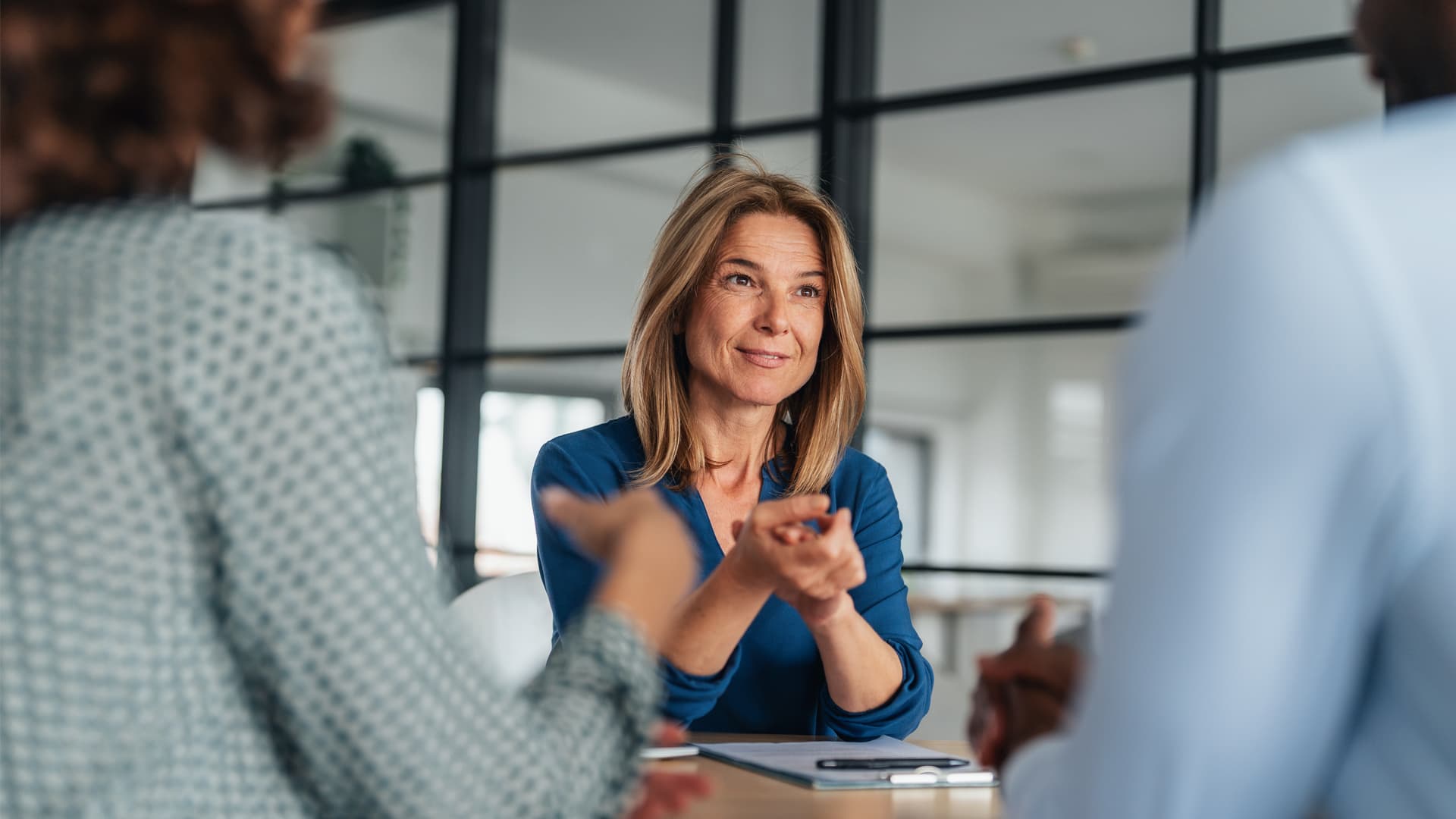 Woman in blue shirt in an office, using skills developed as a psychology MSc student.