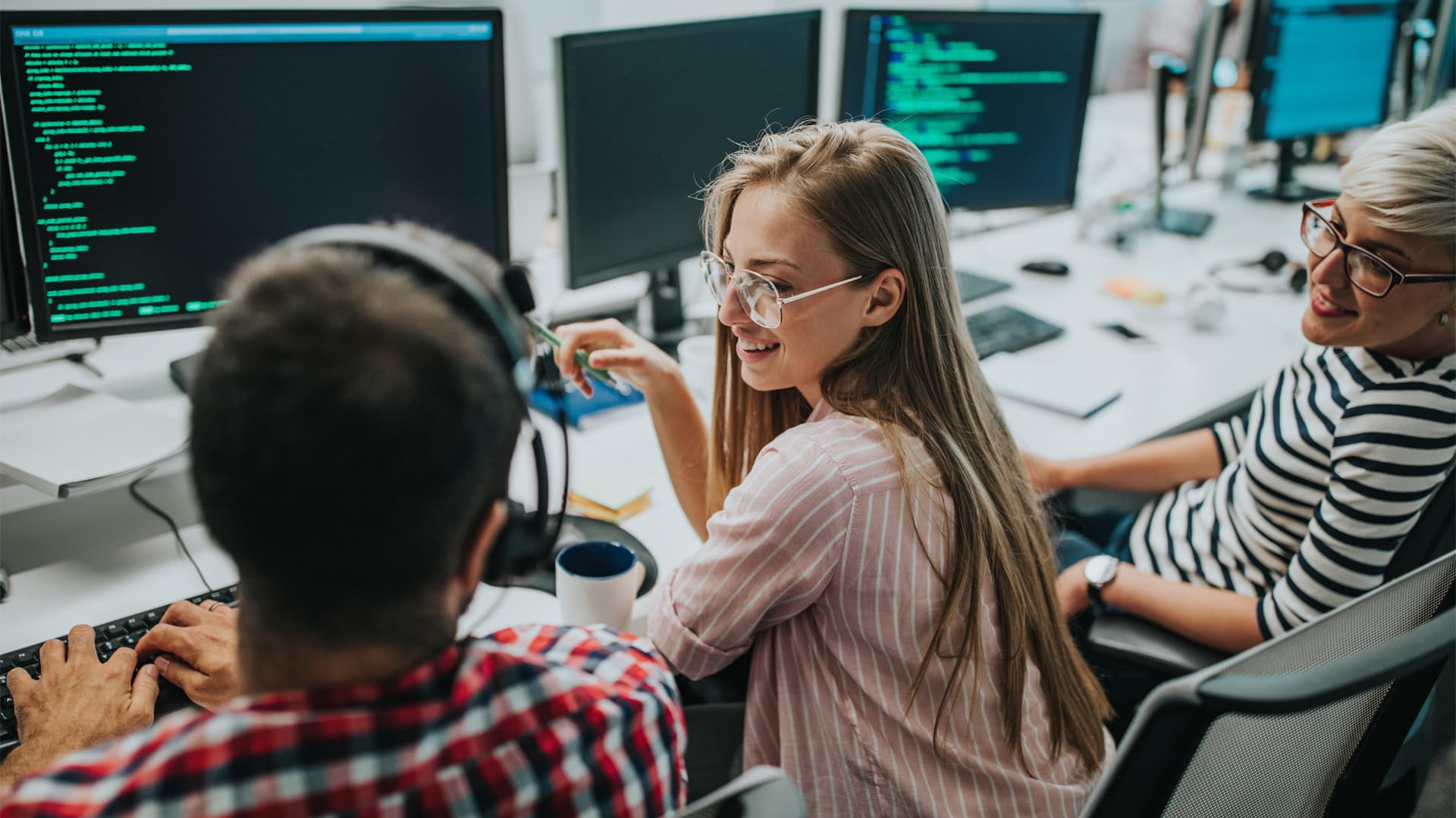 A group of young AI developers sat together developing ai-driven software.