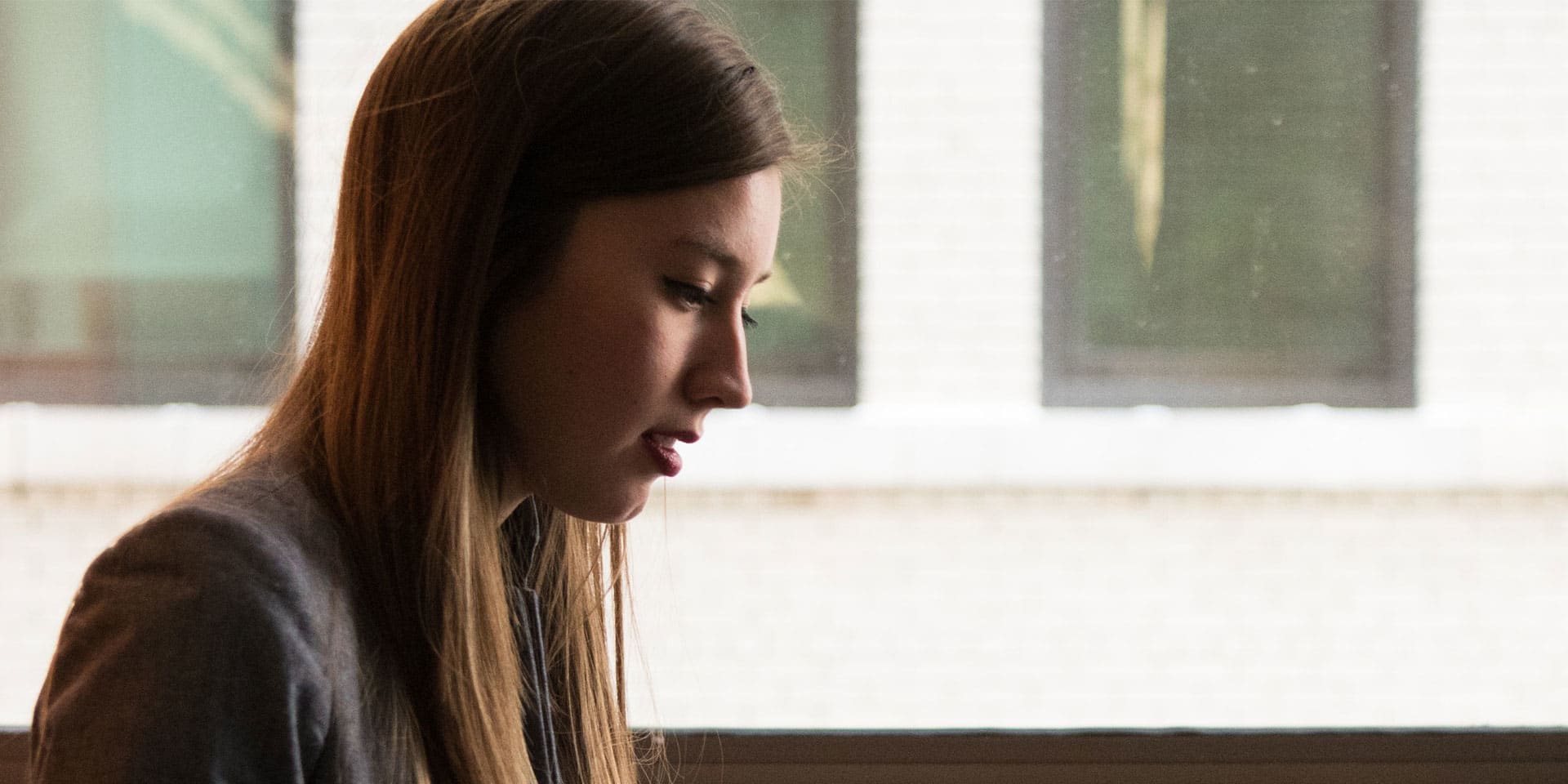 Young woman sitting with a laptop on her lap.