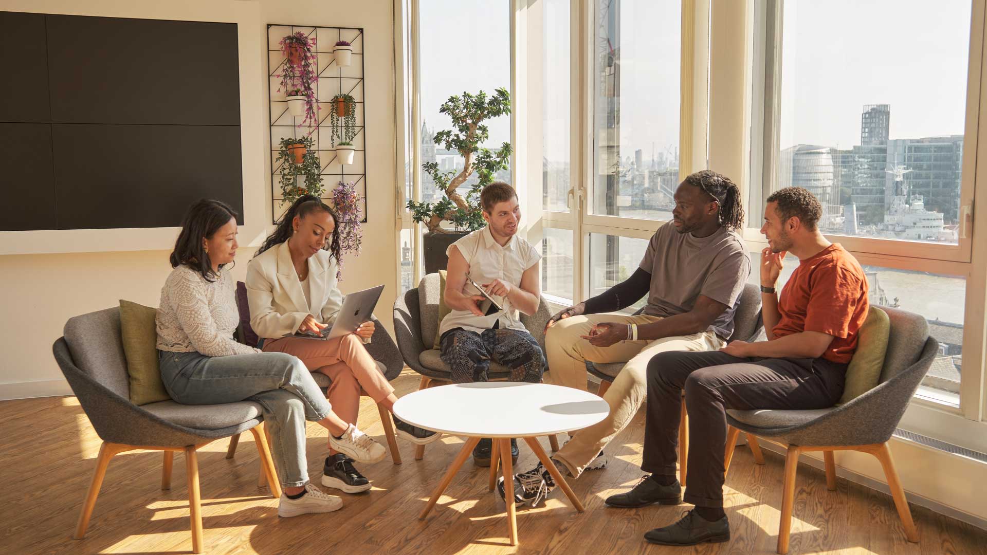 International students sat together excitedly at the Walbrook campus,interacting with study materials for their Business and Management courses.